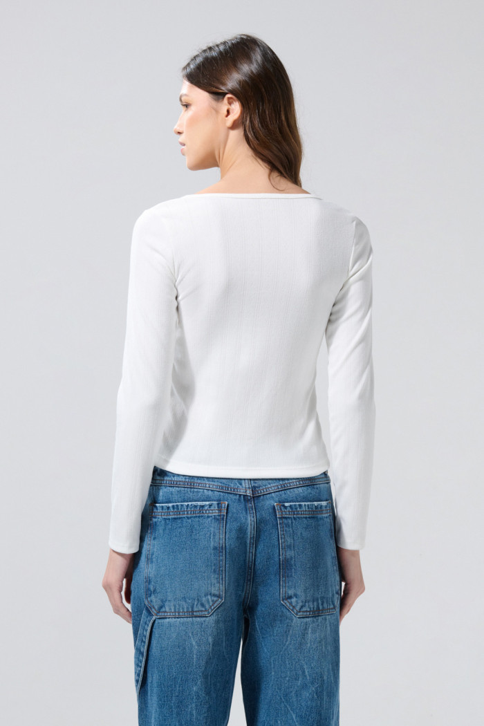 Camiseta blanca con cuello U, manga larga y botones