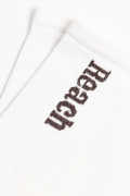 Medias largas cremas claras con texto lateral