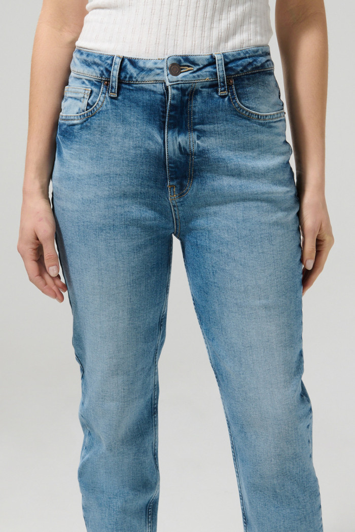 Jean súper tiro alto azul mom con desgastes y bota recta