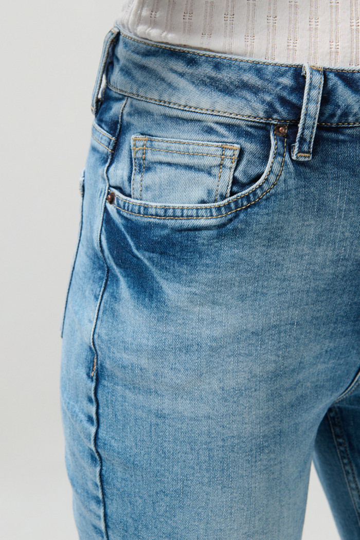 Jean súper tiro alto azul mom con desgastes y bota recta