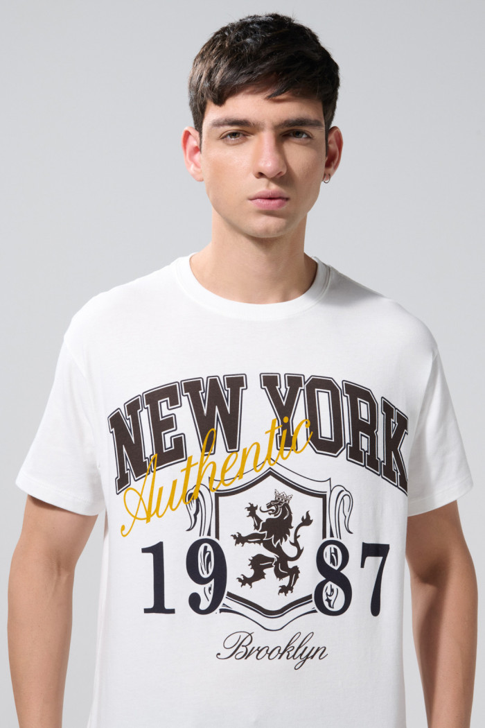Camiseta crema hombro rodado college con manga corta