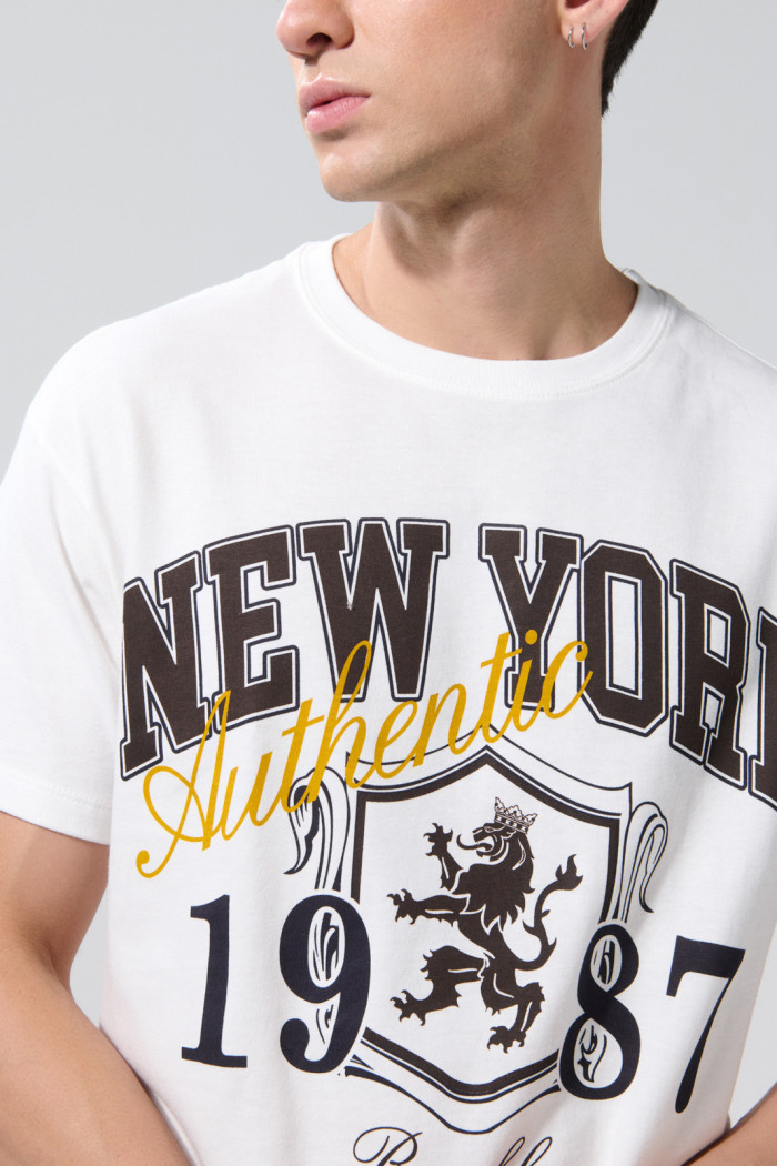 Camiseta crema hombro rodado college con manga corta
