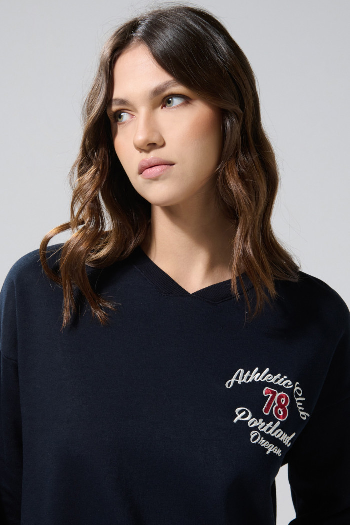 Buzo cuello V oversize azul con diseños college