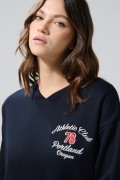 Buzo cuello V oversize azul con diseños college