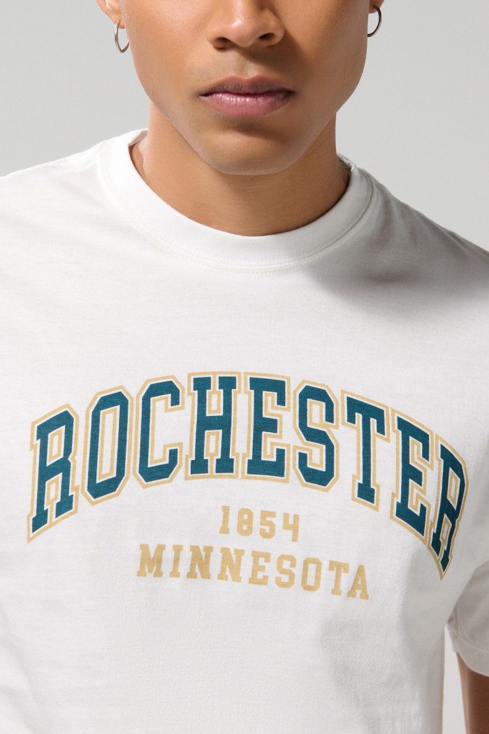 Camiseta crema cuello redondo college con hombro rodado