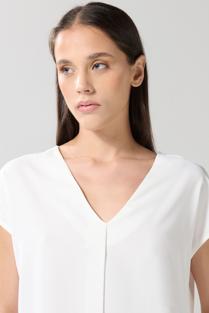 Blusa unicolor manga sisa con escote V y prense delantero