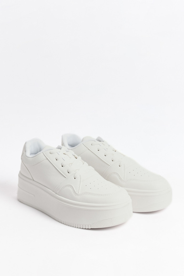 Tenis blancos casuales con perforaciones y suelas altas