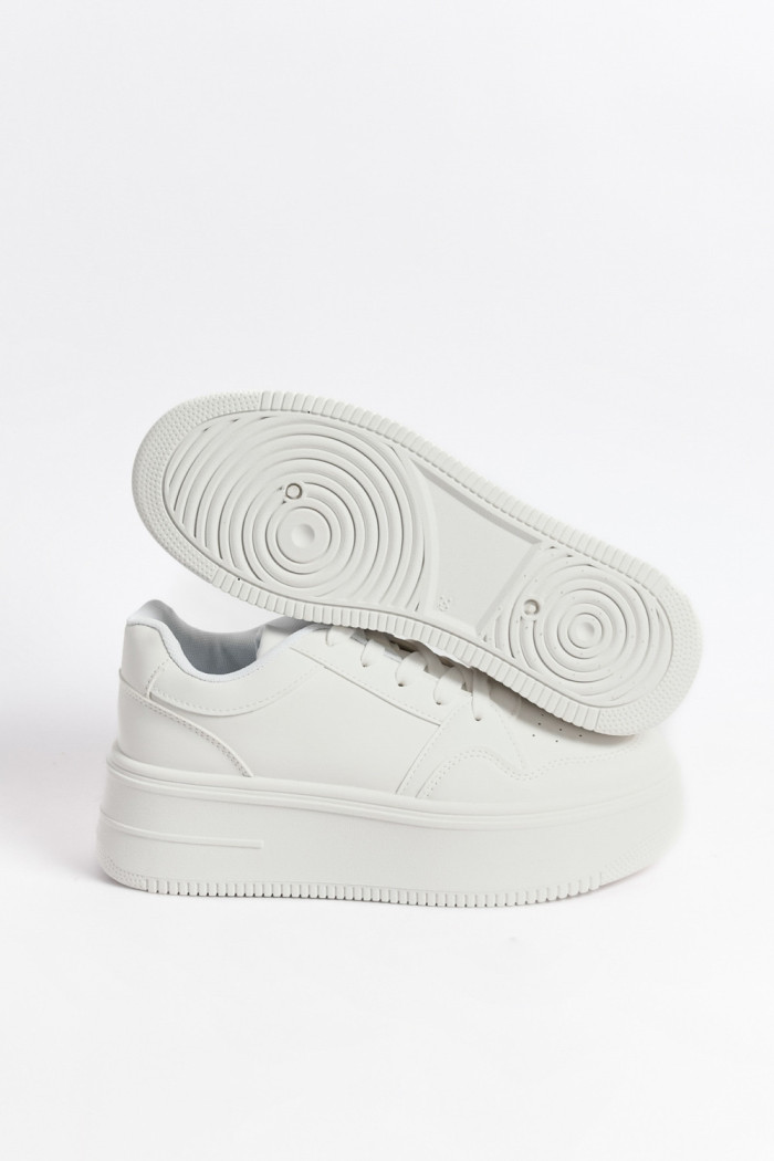 Tenis blancos casuales con perforaciones y suelas altas