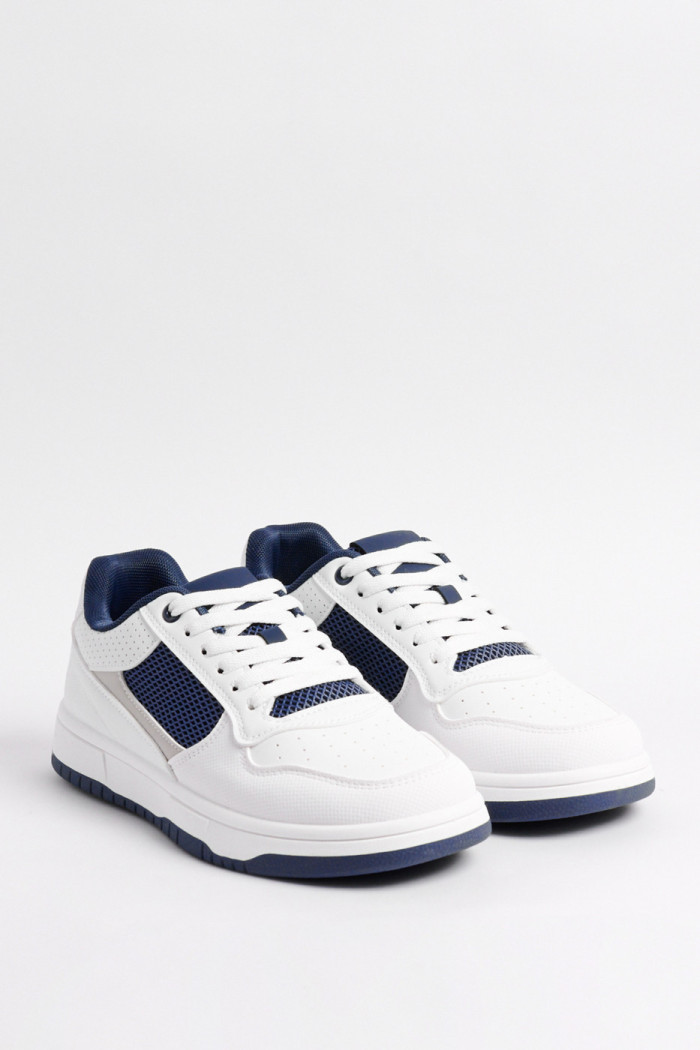 Tenis casuales blancos con contrastes azules y texturas