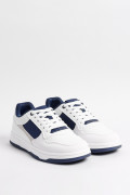 Tenis casuales blancos con contrastes azules y texturas