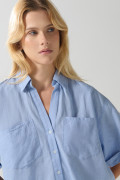 Blusa unicolor con botones, doble bolsillo y manga corta