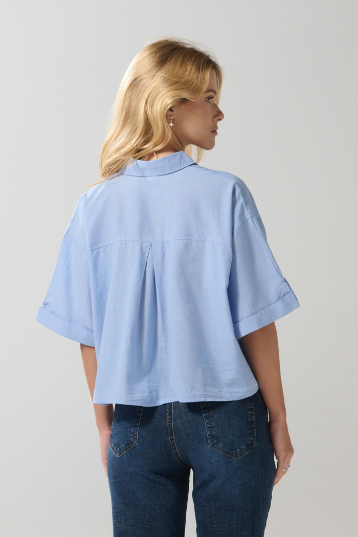 Blusa unicolor con botones, doble bolsillo y manga corta