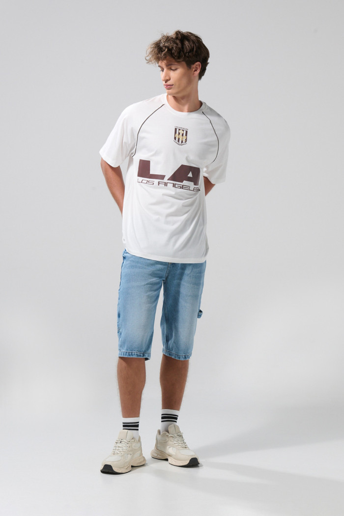 Camiseta oversize crema con arte college y manga ranglan