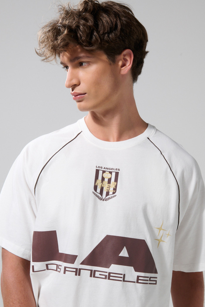 Camiseta oversize crema con arte college y manga ranglan