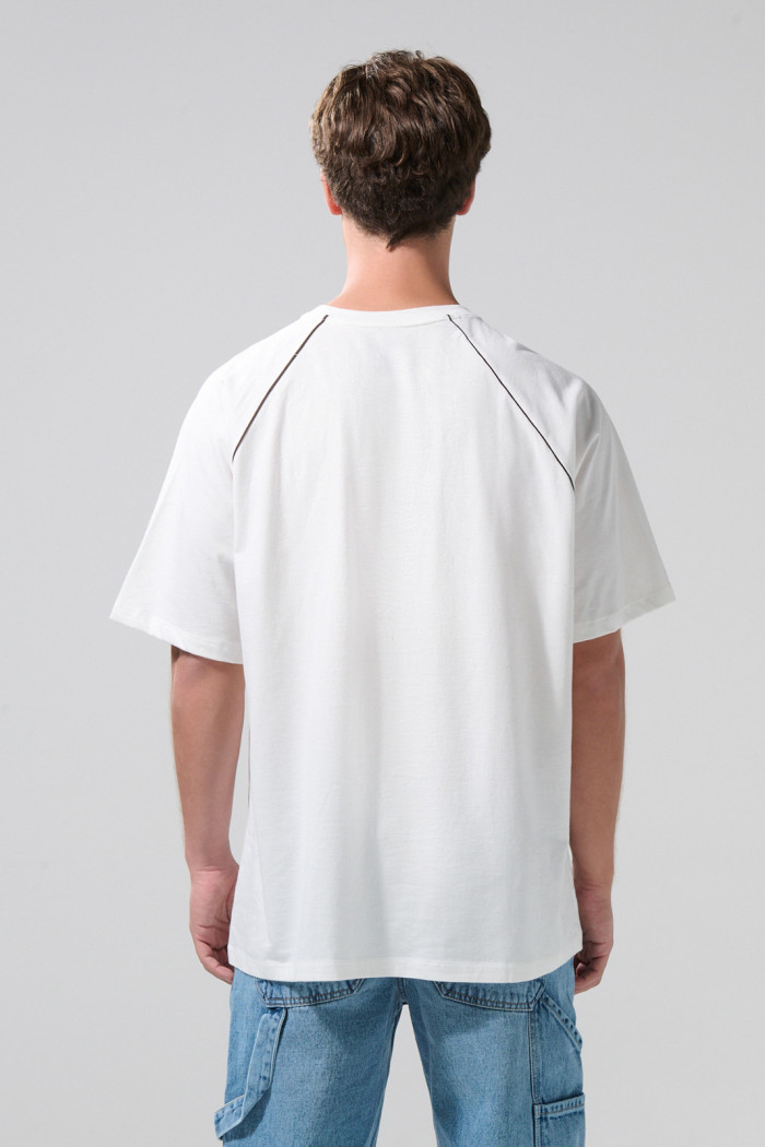 Camiseta oversize crema con arte college y manga ranglan