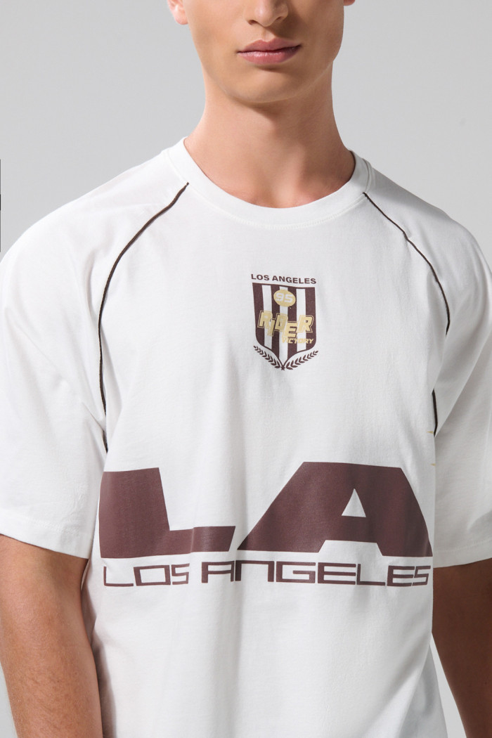 Camiseta oversize crema con arte college y manga ranglan