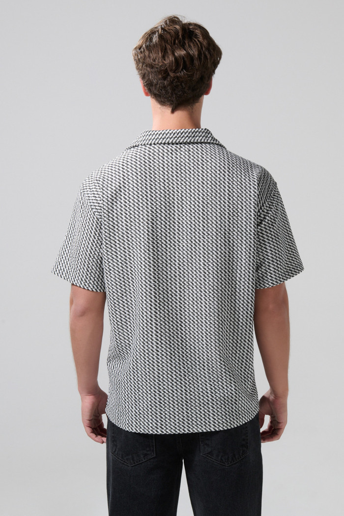 Camisa negra con diseños de figuras y cuello resort