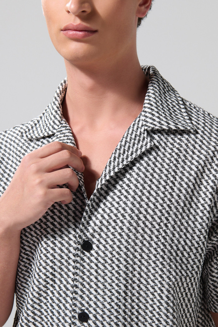 Camisa negra con diseños de figuras y cuello resort