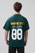 Camiseta verde oscura con diseños college y cuello polo