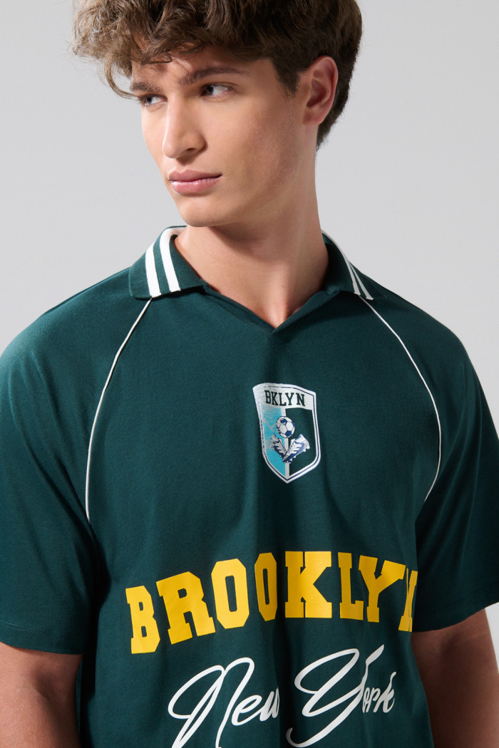 Camiseta verde oscura con diseños college y cuello polo