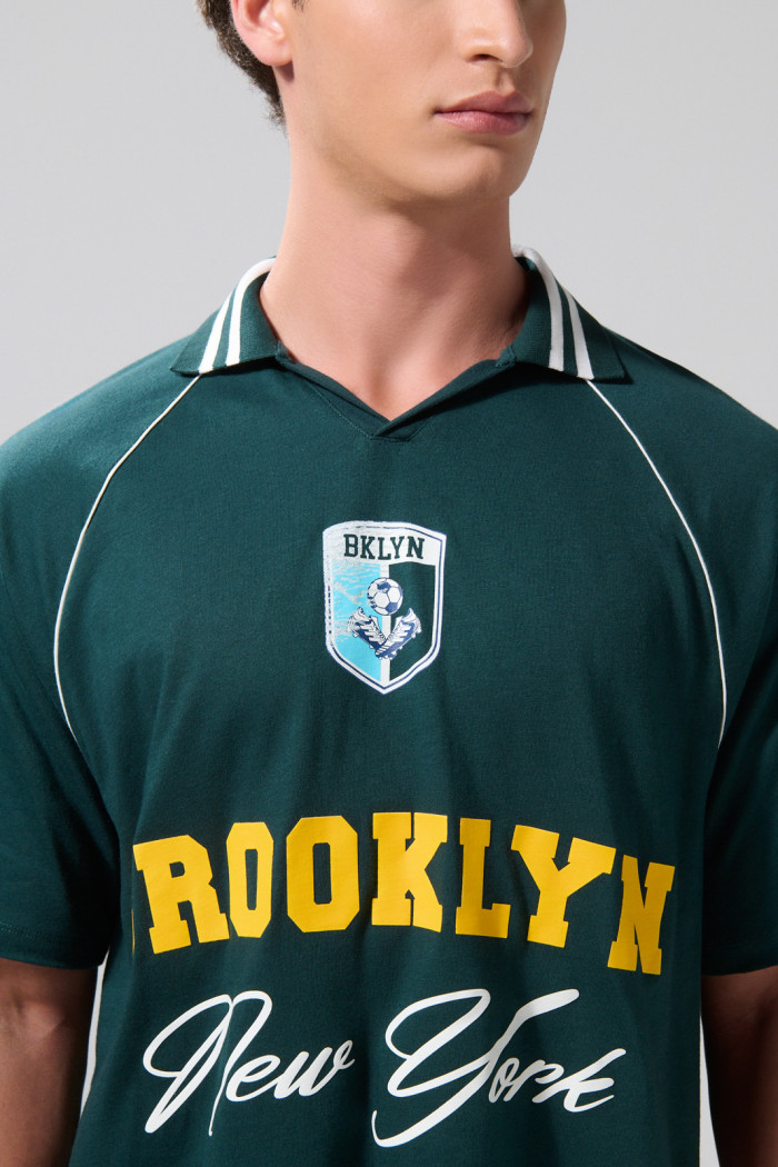 Camiseta verde oscura con diseños college y cuello polo