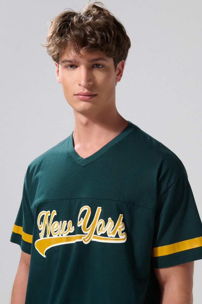Camiseta oversize cuello V verde oscura con diseño college