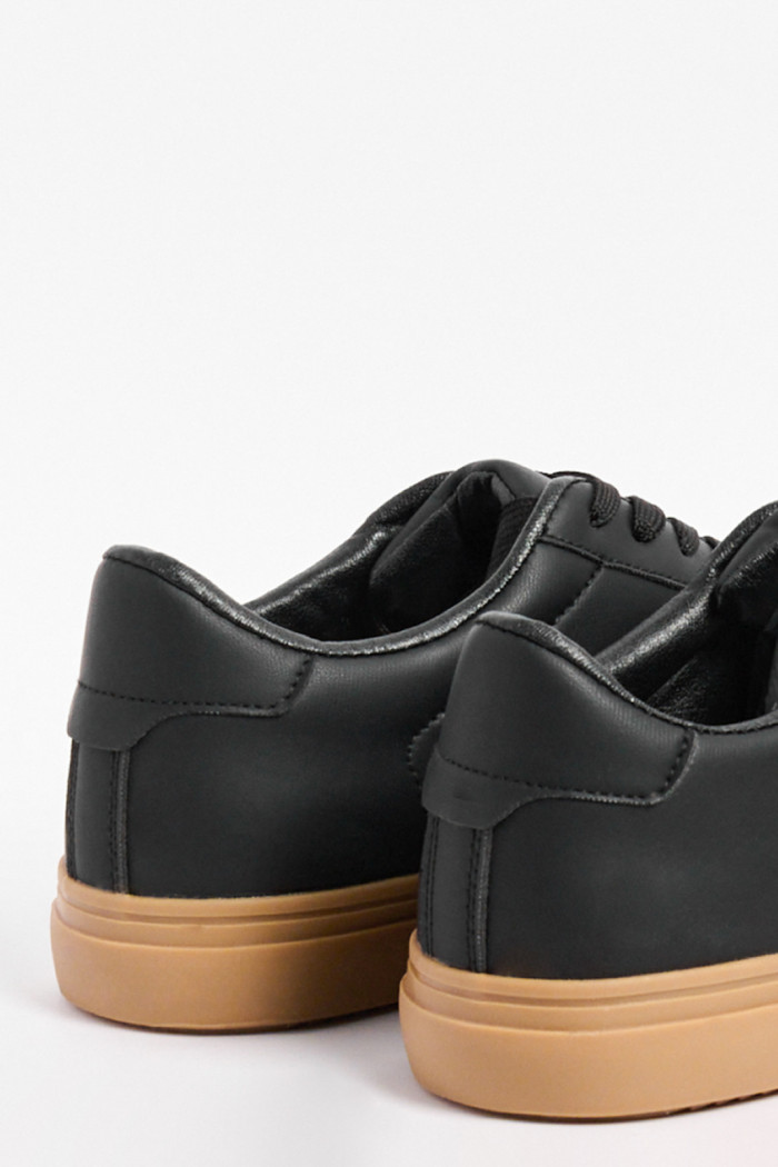 Tenis casuales negros con suelas en contraste planas