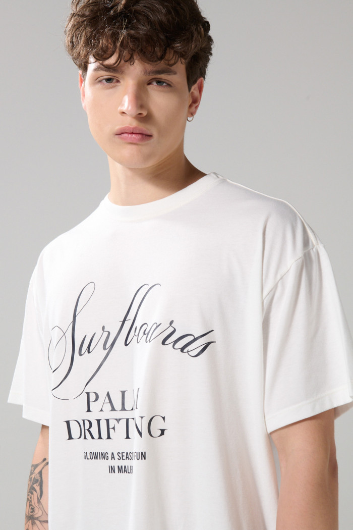 Camiseta oversize crema clara manga corta con texto en frente