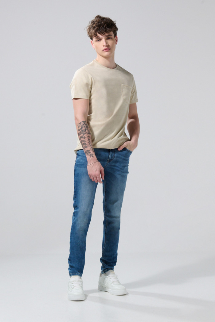Jean skinny azul oscuro con ligeros desgastes y tiro bajo