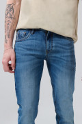 Jean skinny azul oscuro con ligeros desgastes y tiro bajo