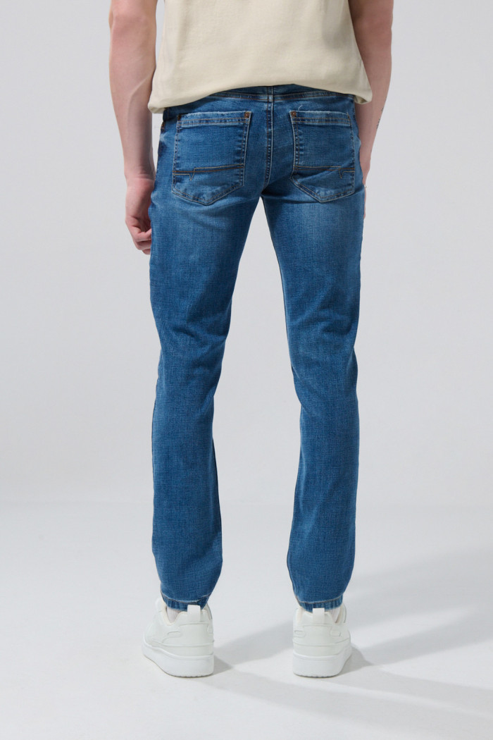 Jean skinny azul oscuro con ligeros desgastes y tiro bajo