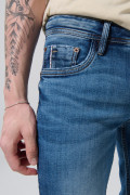 Jean skinny azul oscuro con ligeros desgastes y tiro bajo