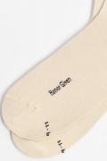 Medias largas kakis claras con texto negro lateral