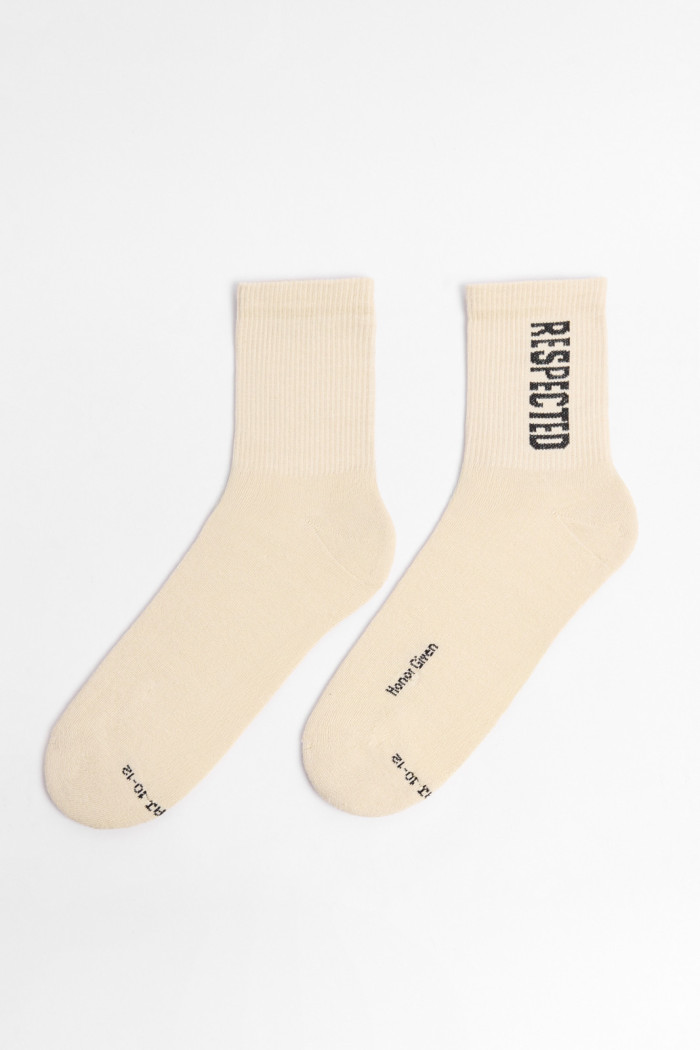 Medias kakis claras largas con diseño de texto negro