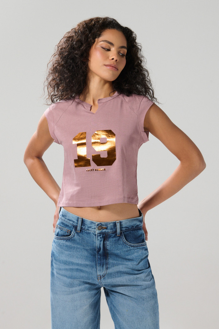 Camiseta rosada con arte college y manga ranglan corta