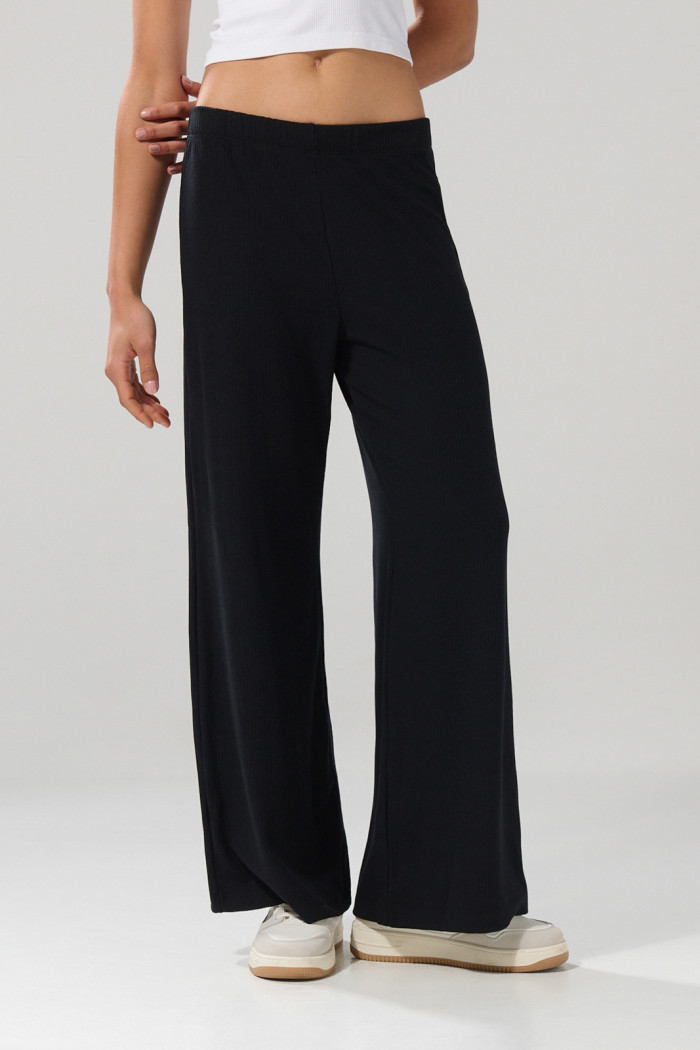 Pantalón flare unicolor en tela acanalada con bota ancha