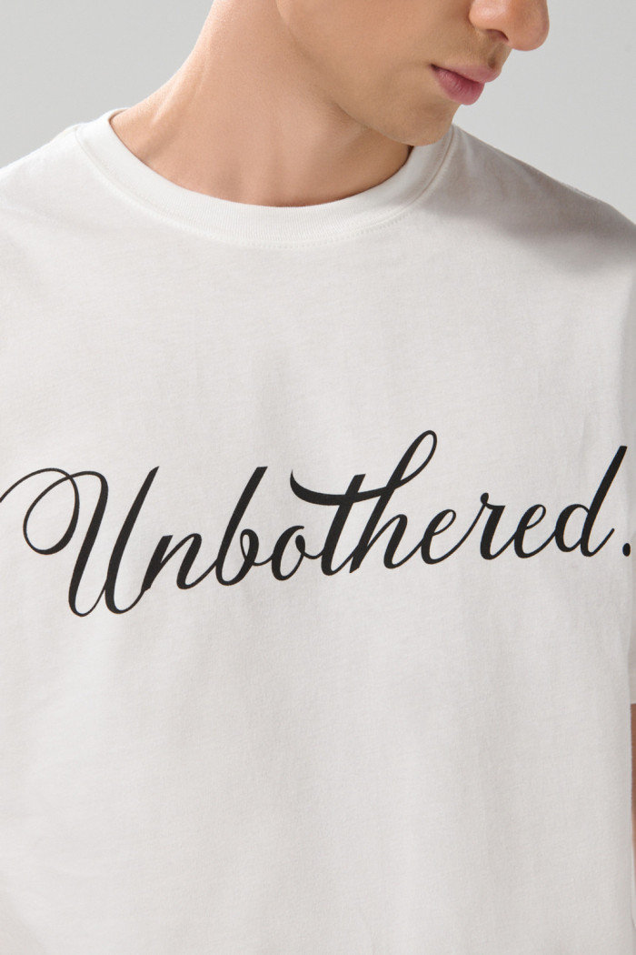 Camiseta crema manga corta con texto y hombro rodado