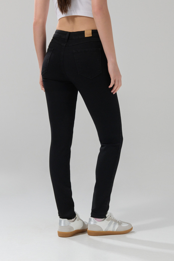 Jean jegging ceñido negro con tiro alto y bolsillos