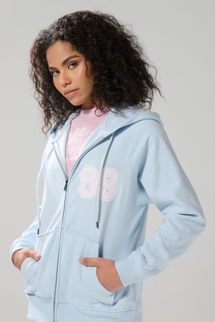Buzo azul college oversize con cremallera y capota