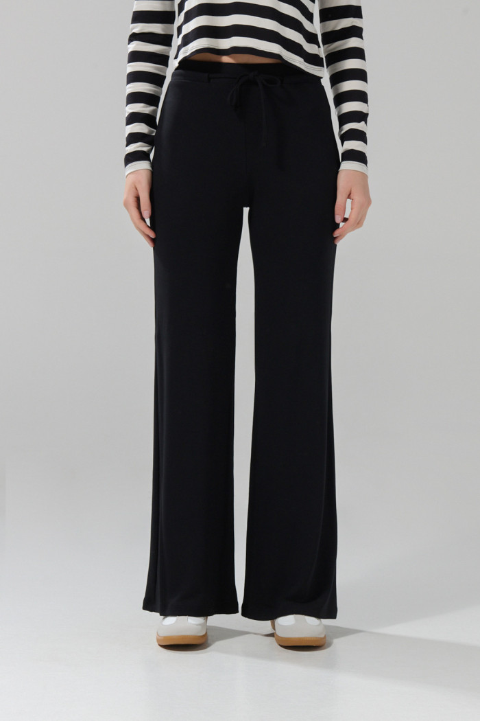 Pantalón tipo flare negro con tiro alto y bota ancha