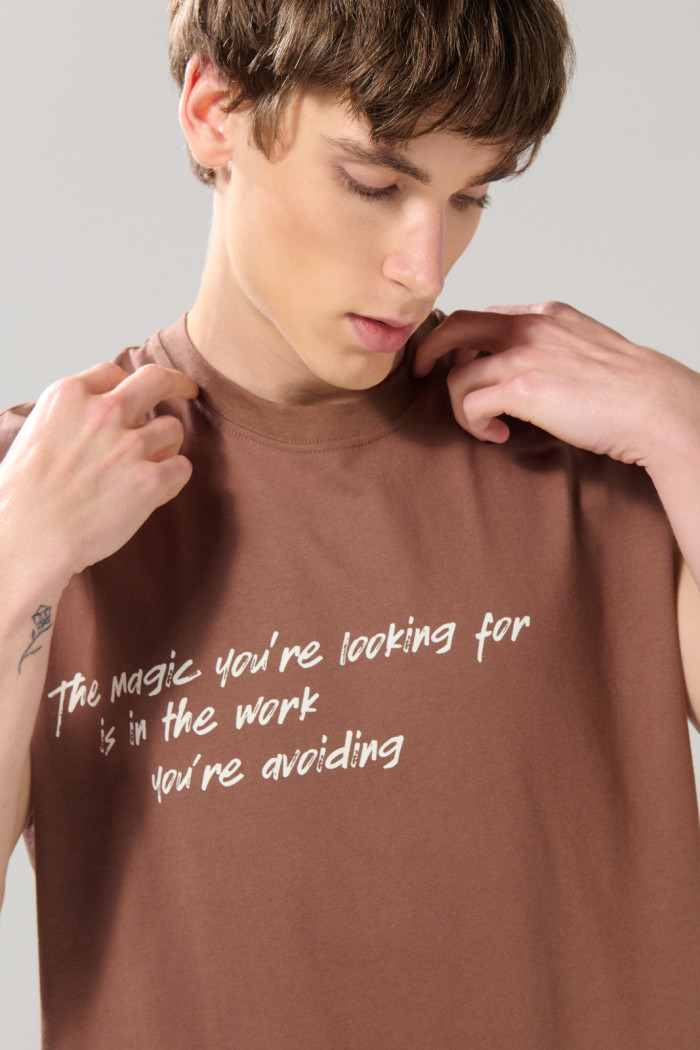 Camiseta manga sisa café medio oversize con textos blancos