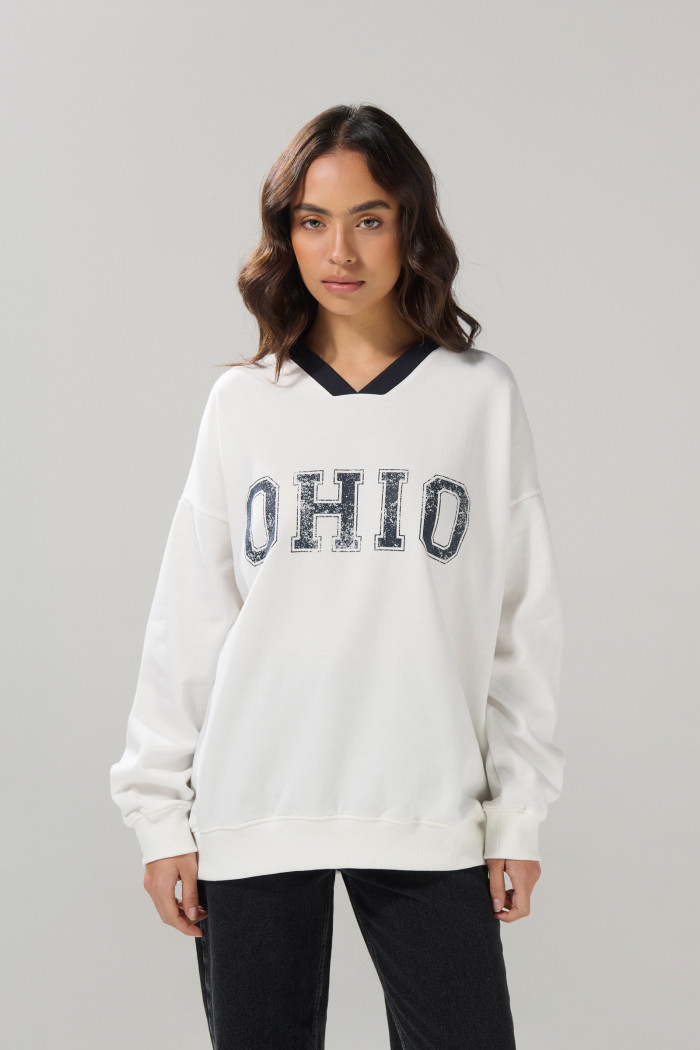 Buzo cuello V crema claro oversize con arte college