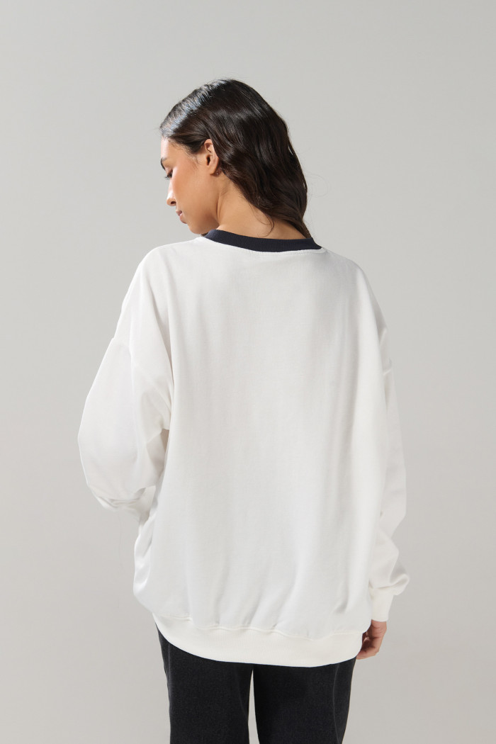 Buzo cuello V crema claro oversize con arte college