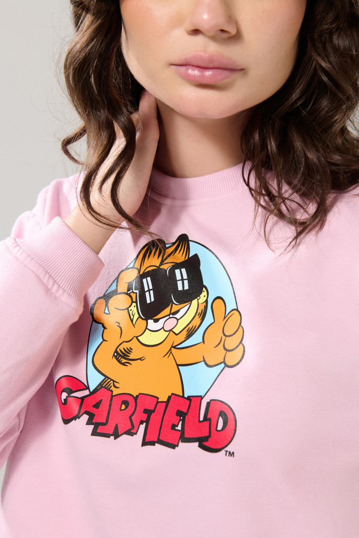 Buzo rosado claro cuello redondo con arte de Garfield