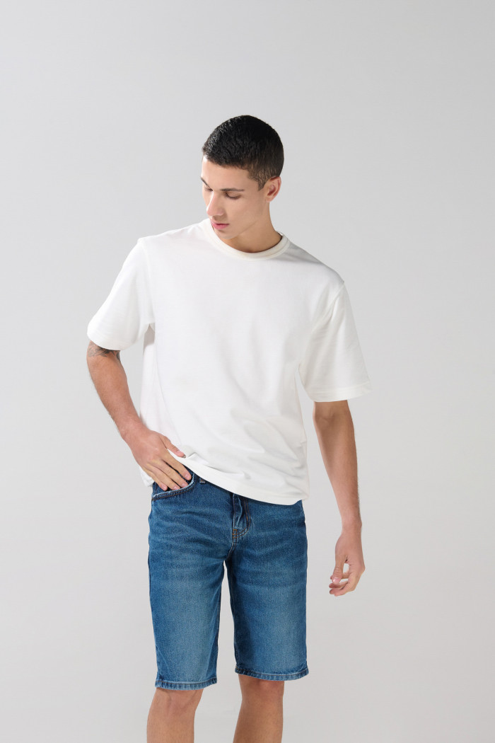 Bermuda de jean slim azul oscura con rotos en frente