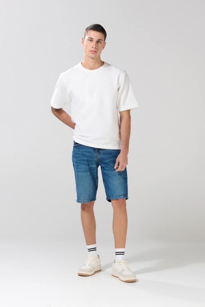 Bermuda de jean slim azul oscura con rotos en frente