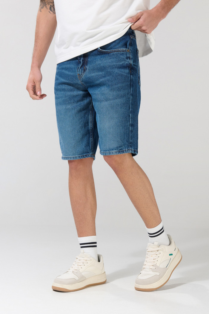 Bermuda de jean slim azul oscura con rotos en frente