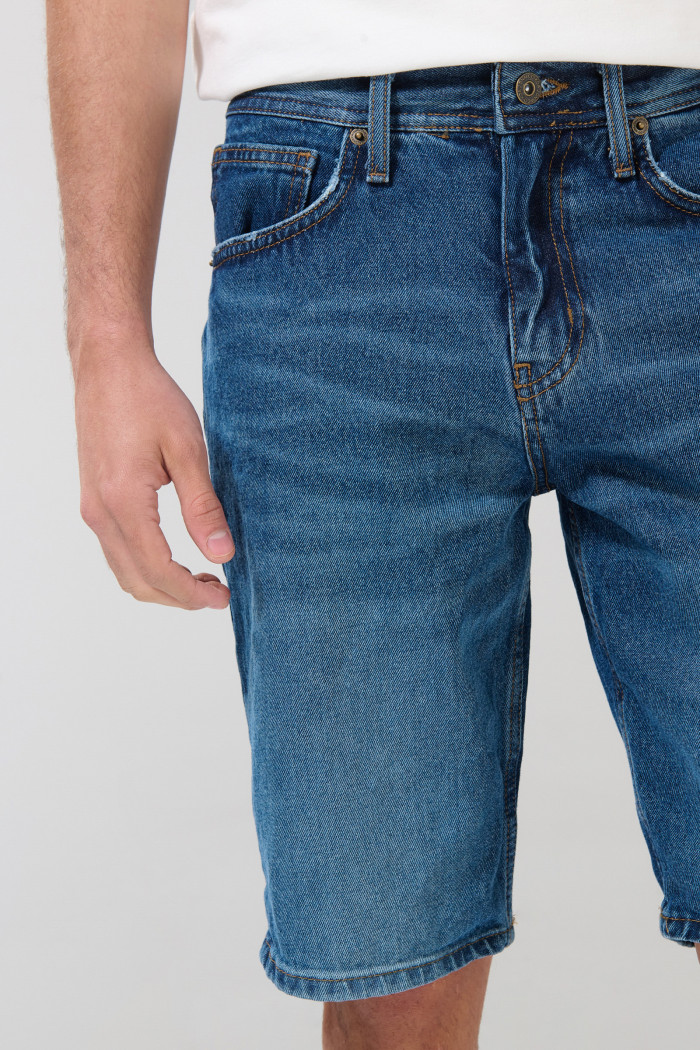 Bermuda de jean slim azul oscura con rotos en frente