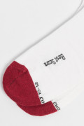 Medias largas cremas claras con texto y contraste rojo
