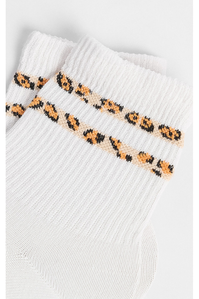 Media urbana corta, con diseño en costado en jacquard de animal print.